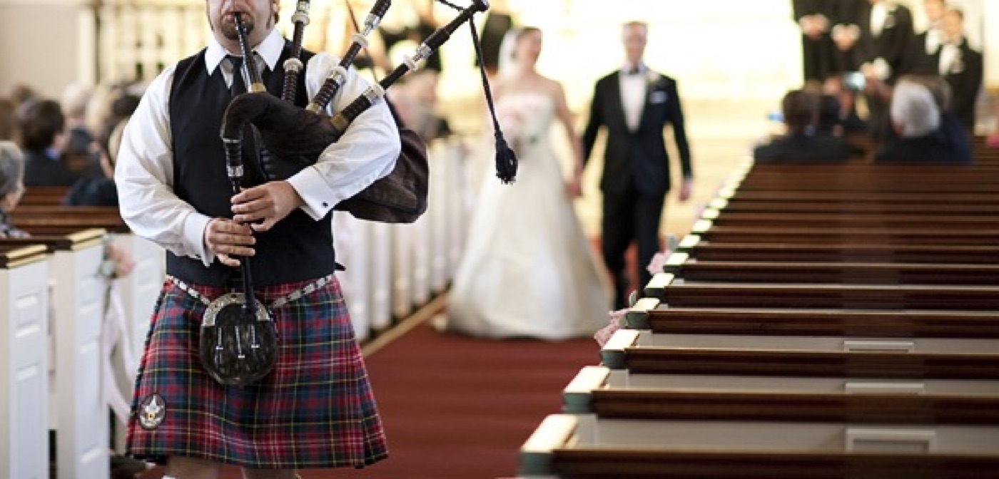 A bagpiper leading the wedding party