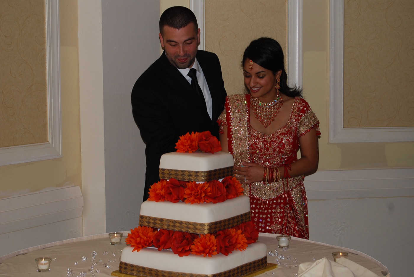 A bride and groom cutting their cake at an Indian wedding