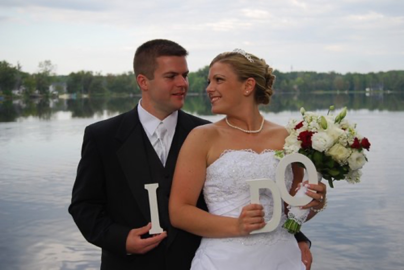A bride and groom by a lake